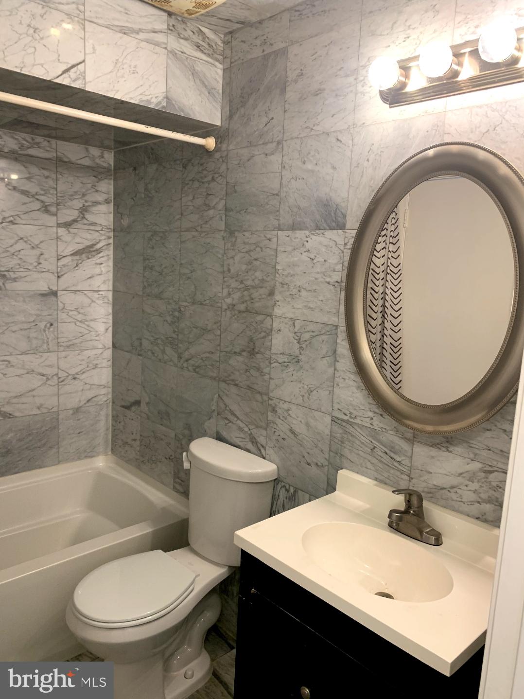 9358 Neil Road, Unit A Philadelphia, PA 19115 - Photo 13 of 24 a bathroom with a toilet a sink and mirror