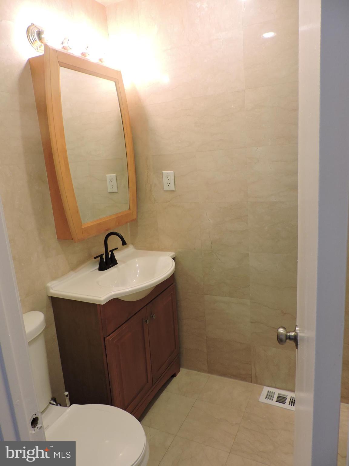 9358 Neil Road, Unit A Philadelphia, PA 19115 - Photo 16 of 24 a bathroom with a sink a toilet and mirror