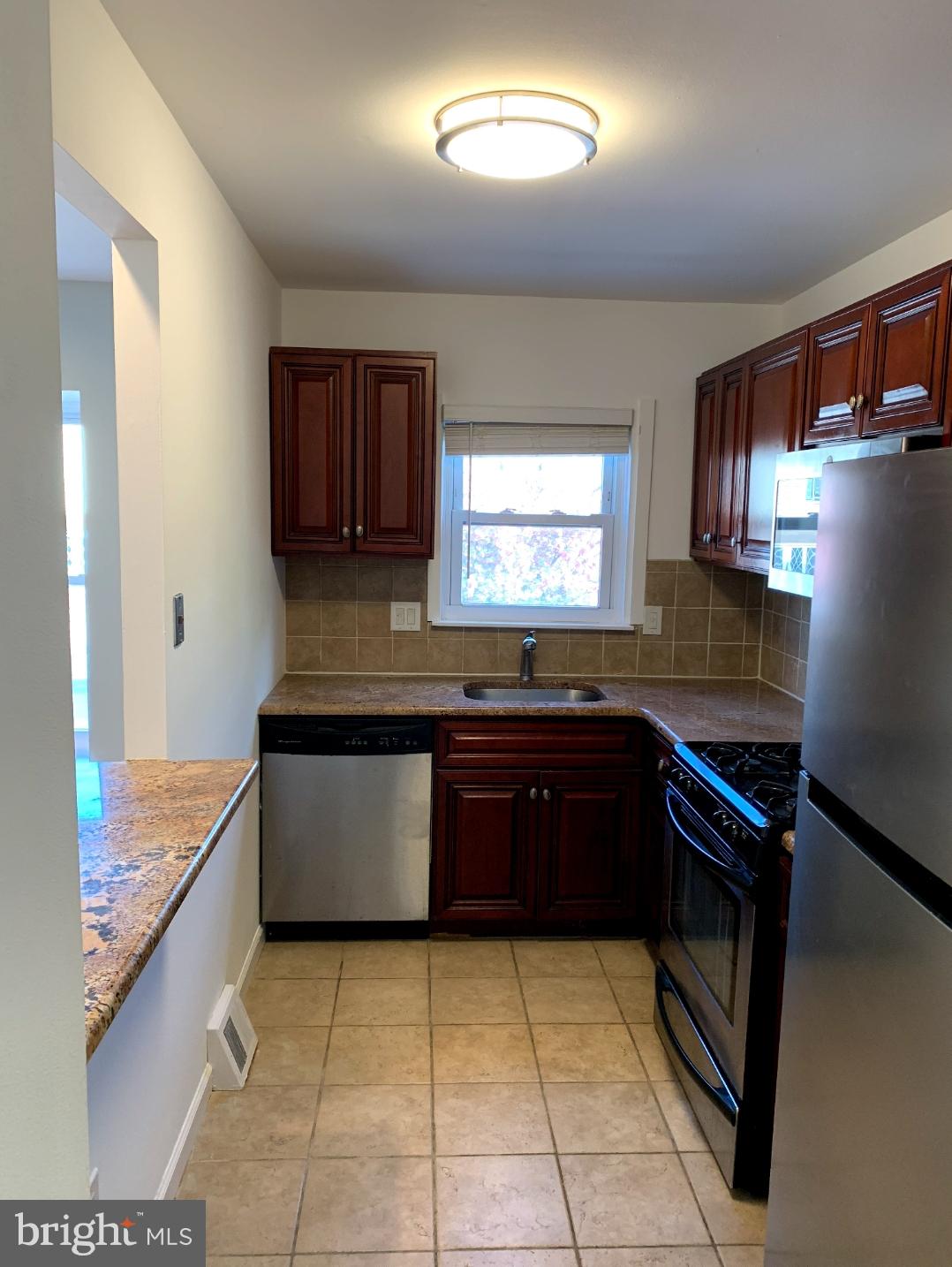 9358 Neil Road, Unit A Philadelphia, PA 19115 - Photo 8 of 24 a kitchen with stainless steel appliances granite countertop a stove a sink and a microwave
