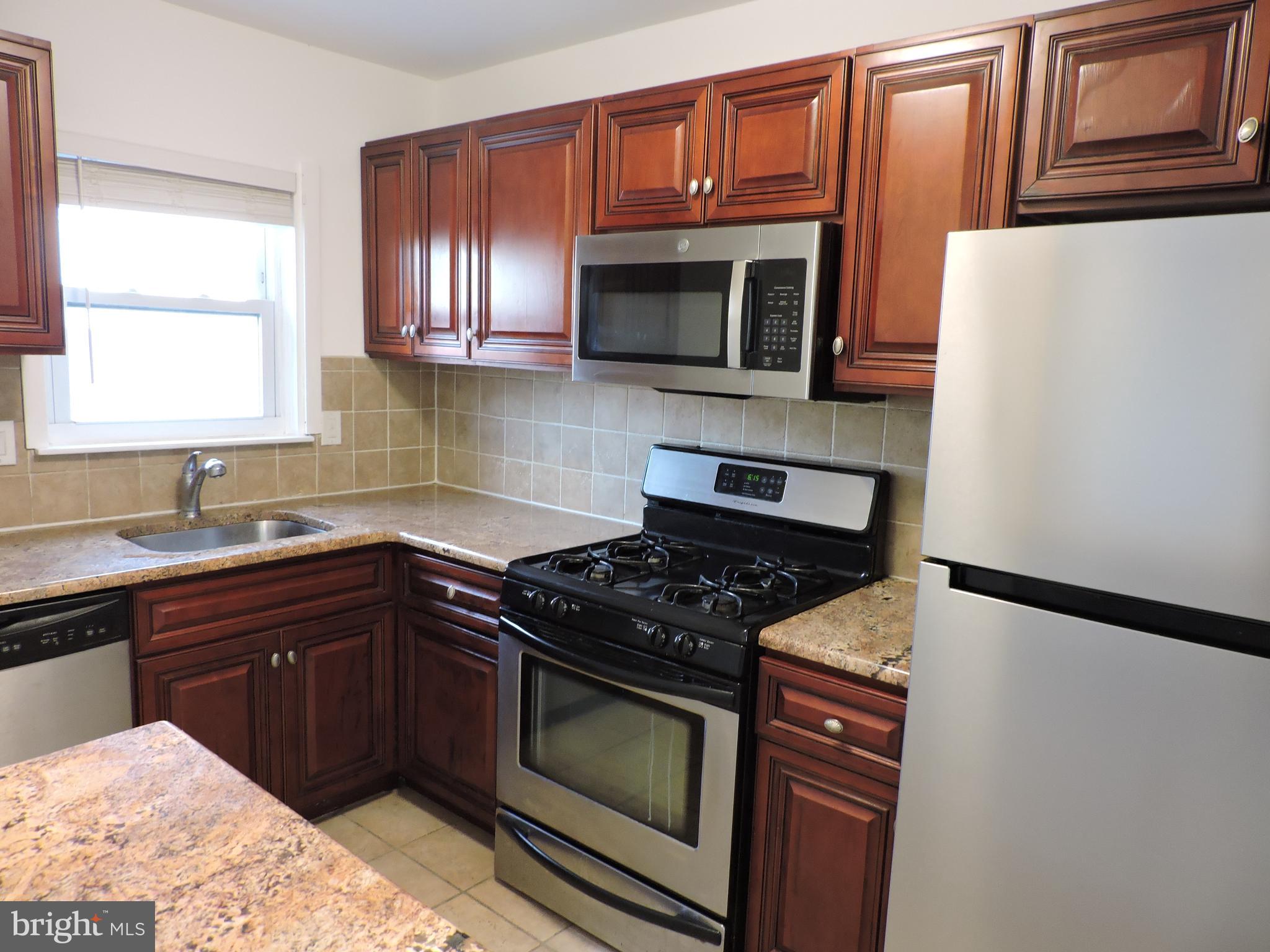 9358 Neil Road, Unit A Philadelphia, PA 19115 - Photo 9 of 24 a kitchen with stainless steel appliances granite countertop a stove and a microwave