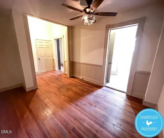 a view of a livingroom with wooden floor and a ceiling fan