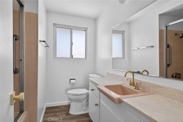 a spacious bathroom with a granite countertop sink a toilet and a mirror