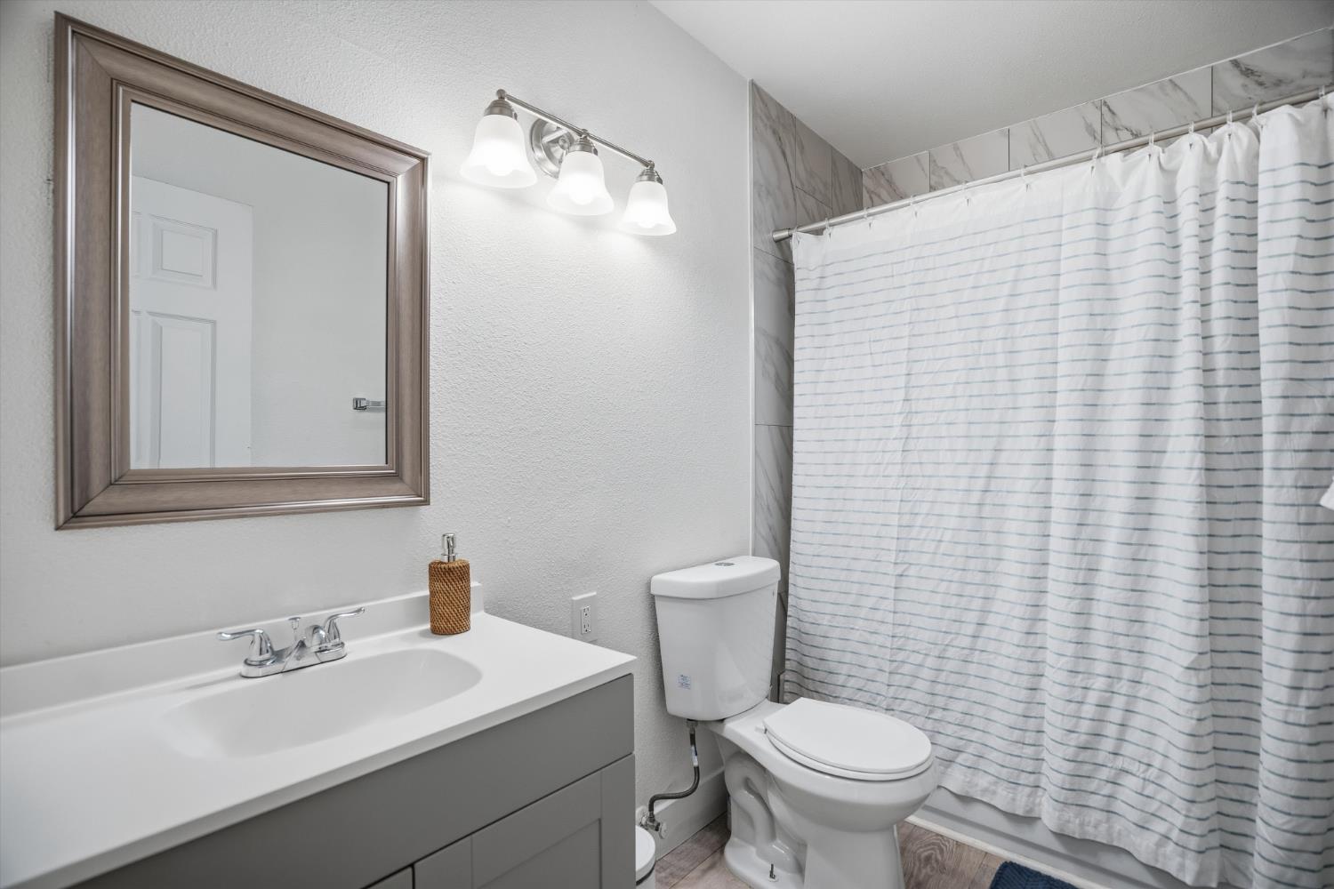 3424 Vintage Drive, Unit 152 Modesto, CA 95356 - Photo 13 of 24 a bathroom with a sink a toilet and mirror