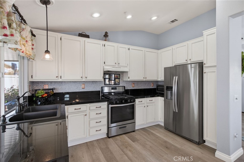 19584 Jill Court Riverside, CA 92508 - Photo 9 of 31 a kitchen with white cabinets and stainless steel appliances