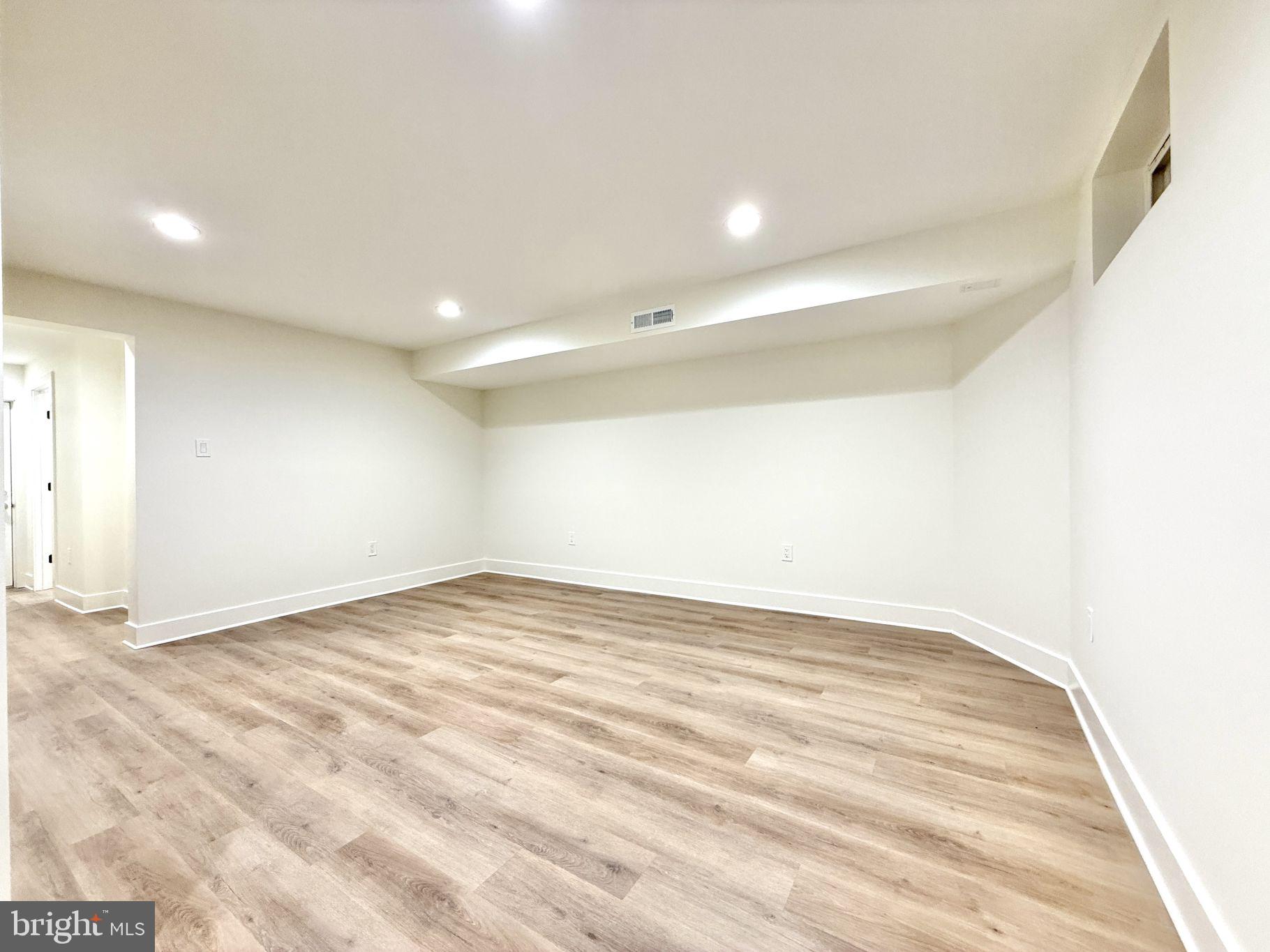 38 Crittenden Street Northeast Washington, DC 20011 - Photo 27 of 48 an empty room with wooden floor and white walls