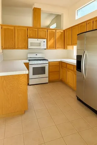 a kitchen with granite countertop a stove and a refrigerator