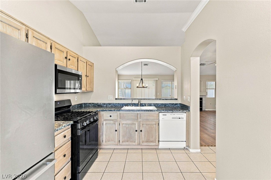 904 Shadowfax Road Henderson, NV 89015 - Photo 8 of 31 Vaulted ceilings and arched openings frame a bright workspace featuring durable tile flooring.