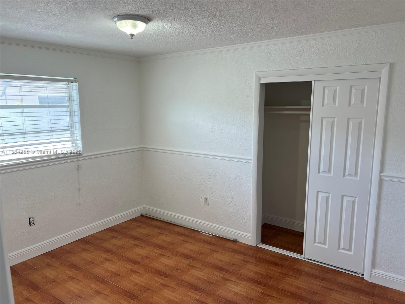 430 East 29th Street, Unit FRONT Hialeah, FL 33013 - Photo 12 of 17 an empty room with wooden floor and windows