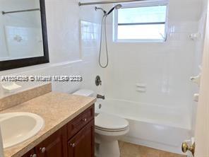 430 East 29th Street, Unit FRONT Hialeah, FL 33013 - Photo 14 of 17 a bathroom with a granite countertop sink toilet and a mirror