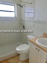 430 East 29th Street, Unit FRONT Hialeah, FL 33013 - Photo 15 of 17 a bathroom with a granite countertop sink a toilet and a mirror