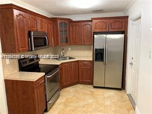 430 East 29th Street, Unit FRONT Hialeah, FL 33013 - Photo 6 of 17 a kitchen with stainless steel appliances granite countertop a refrigerator stove a sink and dishwasher
