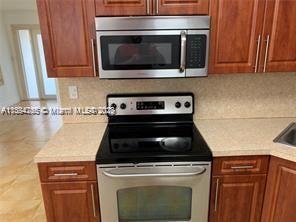 430 East 29th Street, Unit FRONT Hialeah, FL 33013 - Photo 7 of 17 a stove top oven sitting inside of a kitchen and stainless steel appliances