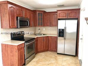 430 East 29th Street, Unit FRONT Hialeah, FL 33013 - Photo 8 of 17 a kitchen with stainless steel appliances granite countertop a refrigerator stove a sink and a microwave
