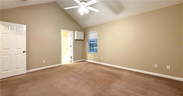 an empty room with a ceiling fan and a window