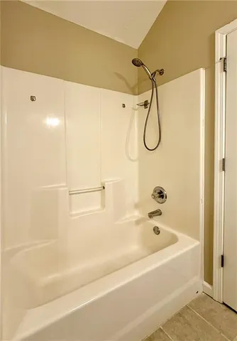 a bathroom with a bath tub with a shower