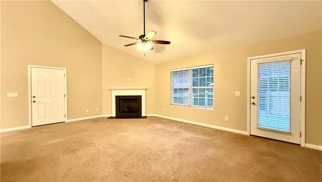 a view of an empty room with a fireplace and a window