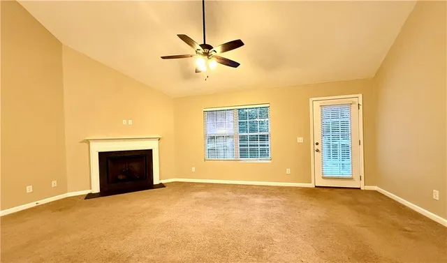 a view of an empty room with a fireplace and a window