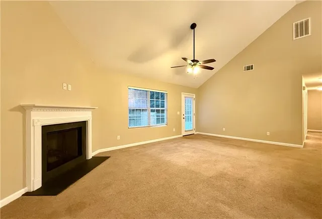 a view of an empty room with a fireplace and a window