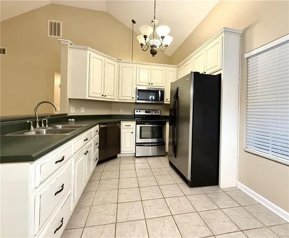 a kitchen with stainless steel appliances cabinets a sink and a window
