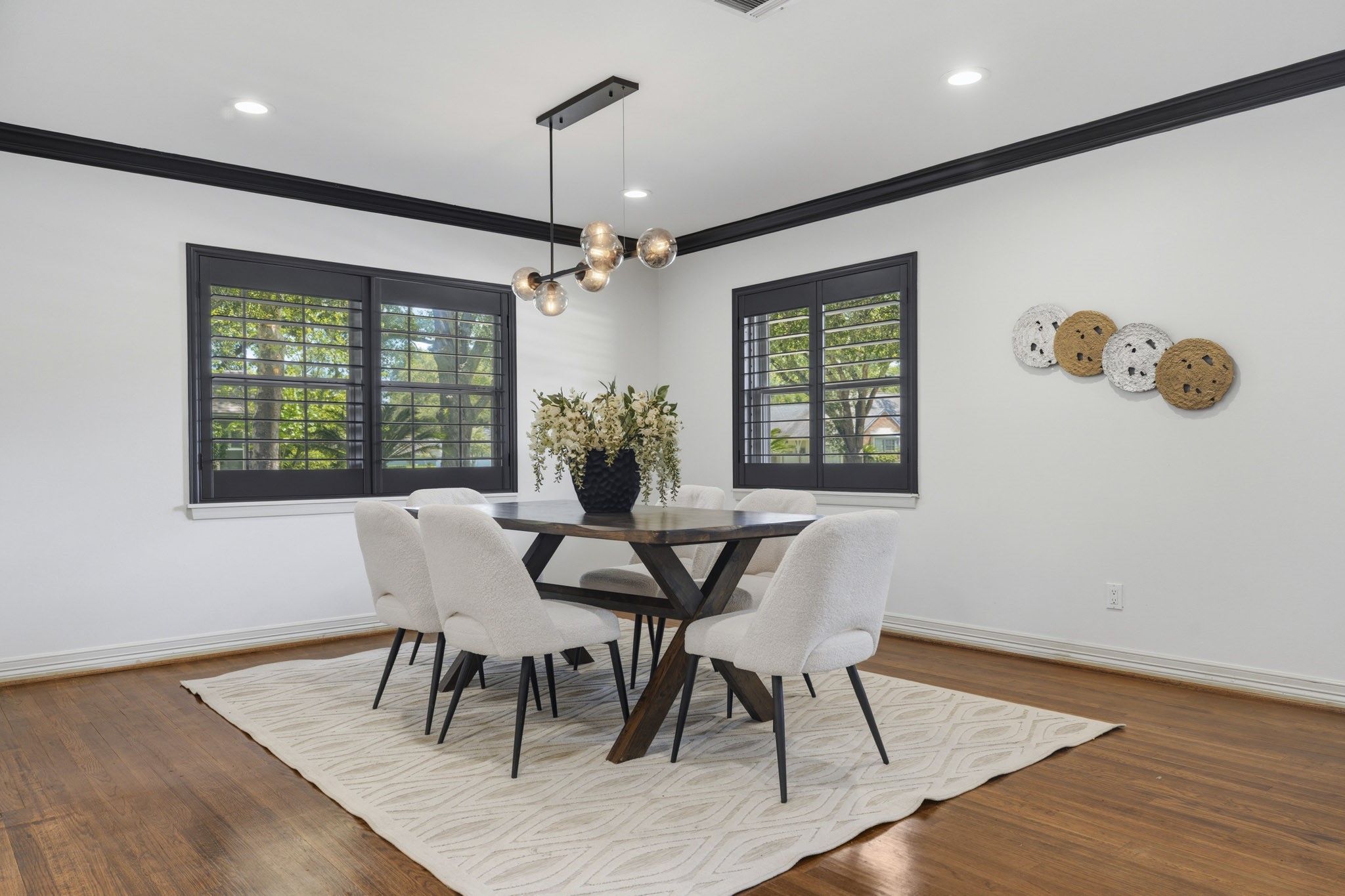 2302 Chimney Rock Road Houston, TX 77056 - Photo 7 of 28 Formal dining room with designer lighting, custom plantation shutters, original hardwood flooring, fresh paint throughout, and crown molding. Spacious and can fit an 8 top dining table.