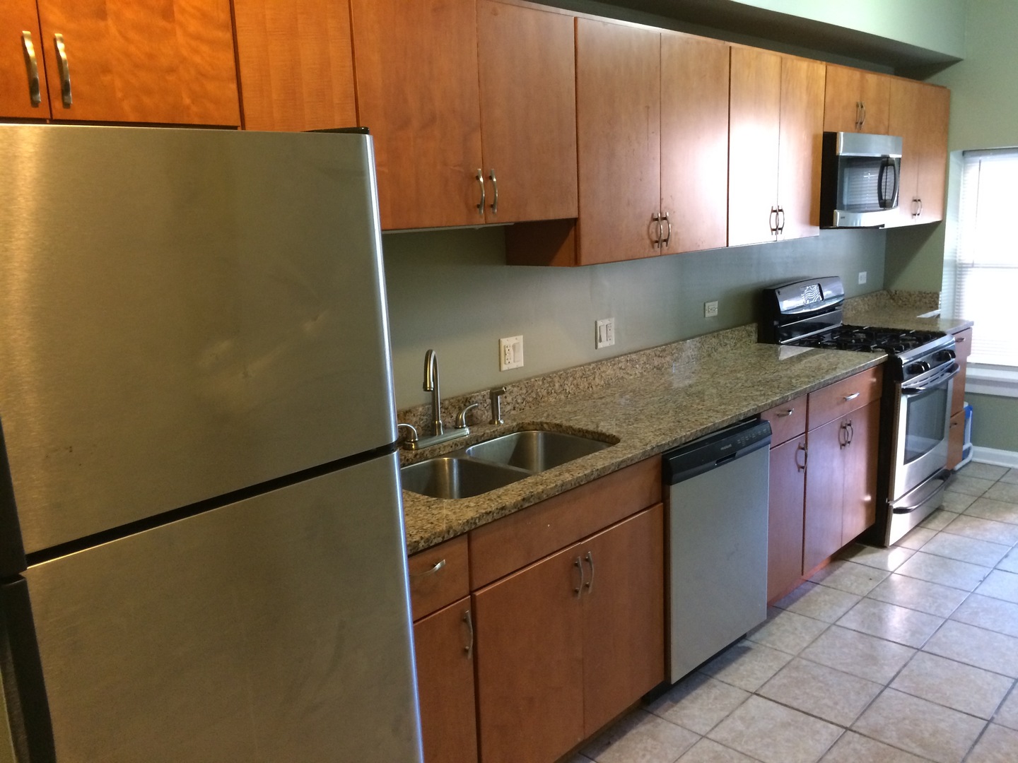 4407 West Adams Street Chicago, IL 60624 - Photo 3 of 10 a kitchen with stainless steel appliances granite countertop a sink stove and refrigerator