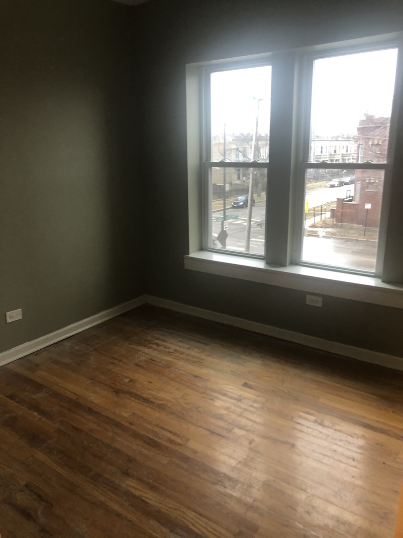 4407 West Adams Street Chicago, IL 60624 - Photo 4 of 10 an empty room with wooden floor and windows