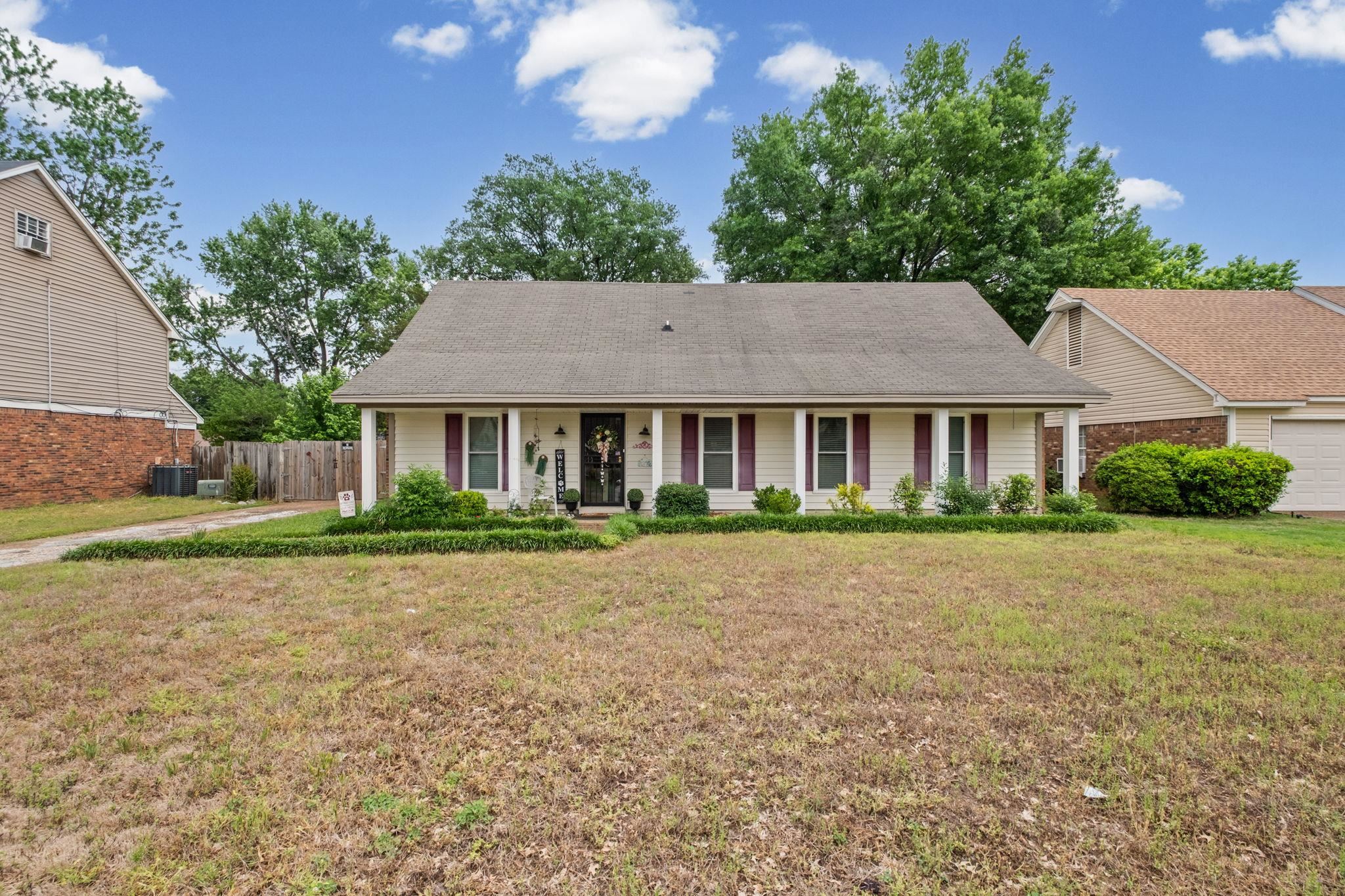 a front view of a house with a yard and trees