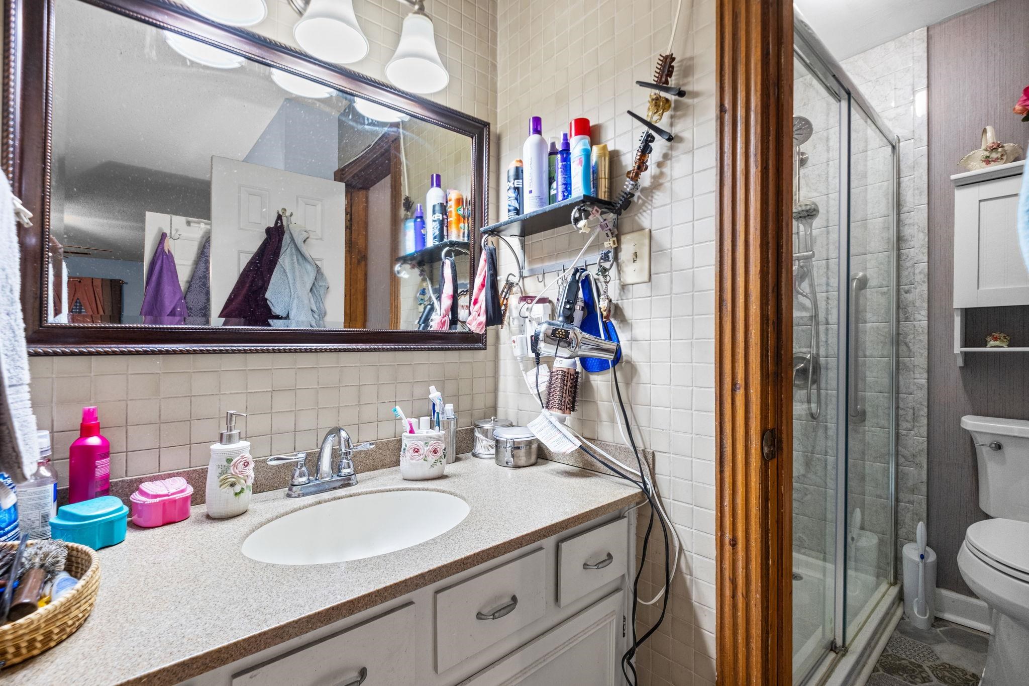 4572 Benoit Drive Memphis, TN 38141 - Photo 14 of 25 a bathroom with a sink vanity mirror and toilet