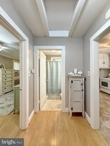 a view of a hallway with wooden floor windows and a livingroom
