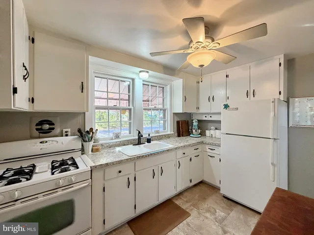 a kitchen with stainless steel appliances a stove a sink cabinets and a refrigerator