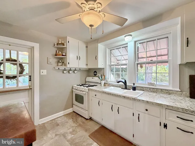 a bathroom with a granite countertop sink and a window
