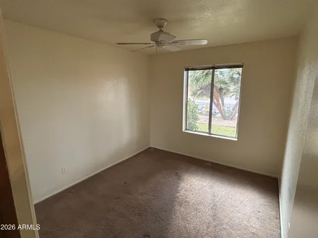an empty room with a fan and a ceiling fan