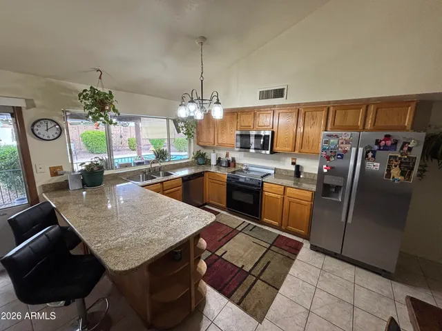 a kitchen with stainless steel appliances granite countertop a sink a stove and a refrigerator