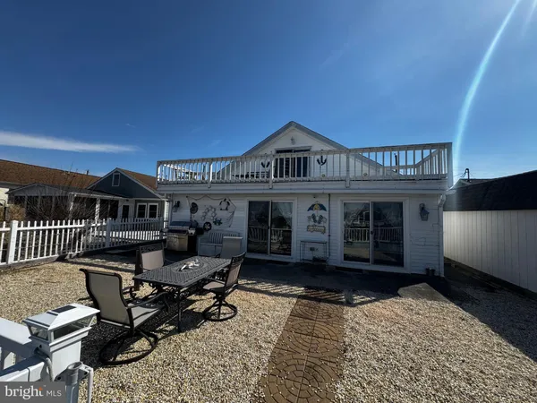 a view of a patio with table and chairs with wooden floor and fence