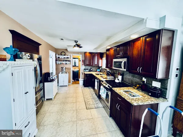 a large kitchen with stainless steel appliances granite countertop a stove refrigerator and cabinets