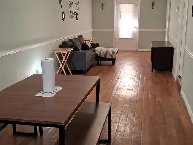 a living room with furniture and wooden floor