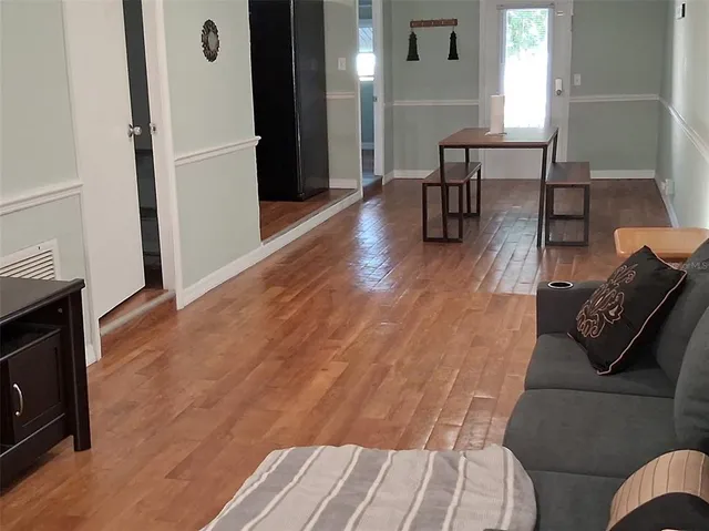 a living room with furniture and a wooden floor