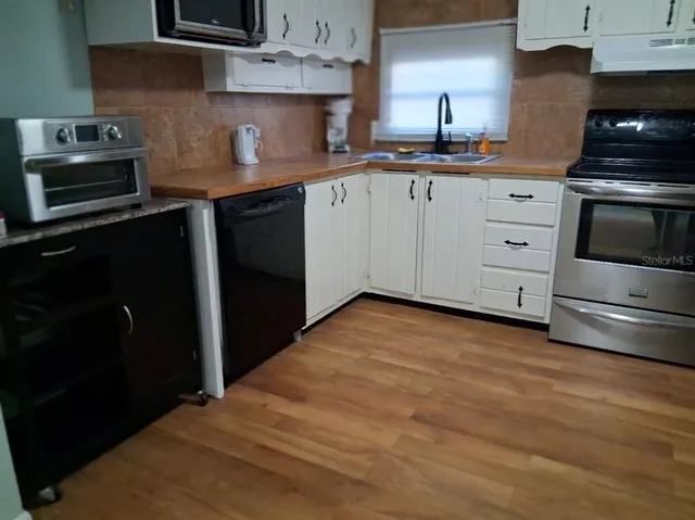 a kitchen with stainless steel appliances granite countertop a stove a sink and a refrigerator