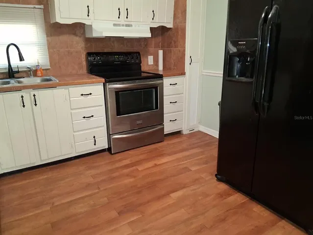 a kitchen with stainless steel appliances a stove and a microwave