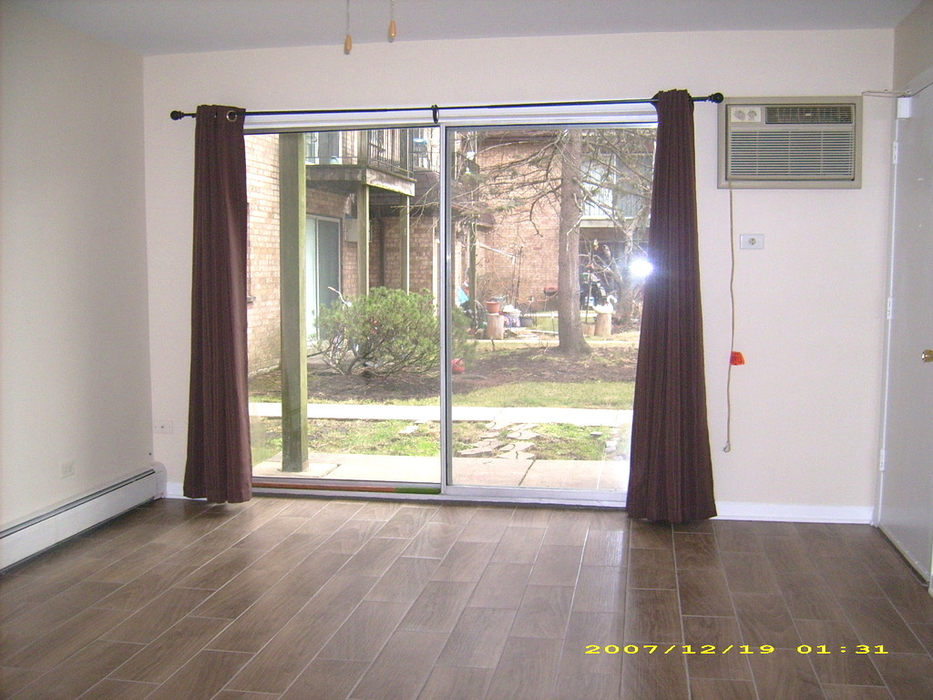 115 East Dundee Road, Unit 1S Wheeling, IL 60090 - Photo 3 of 12 a view of an empty room with wooden floor and a window