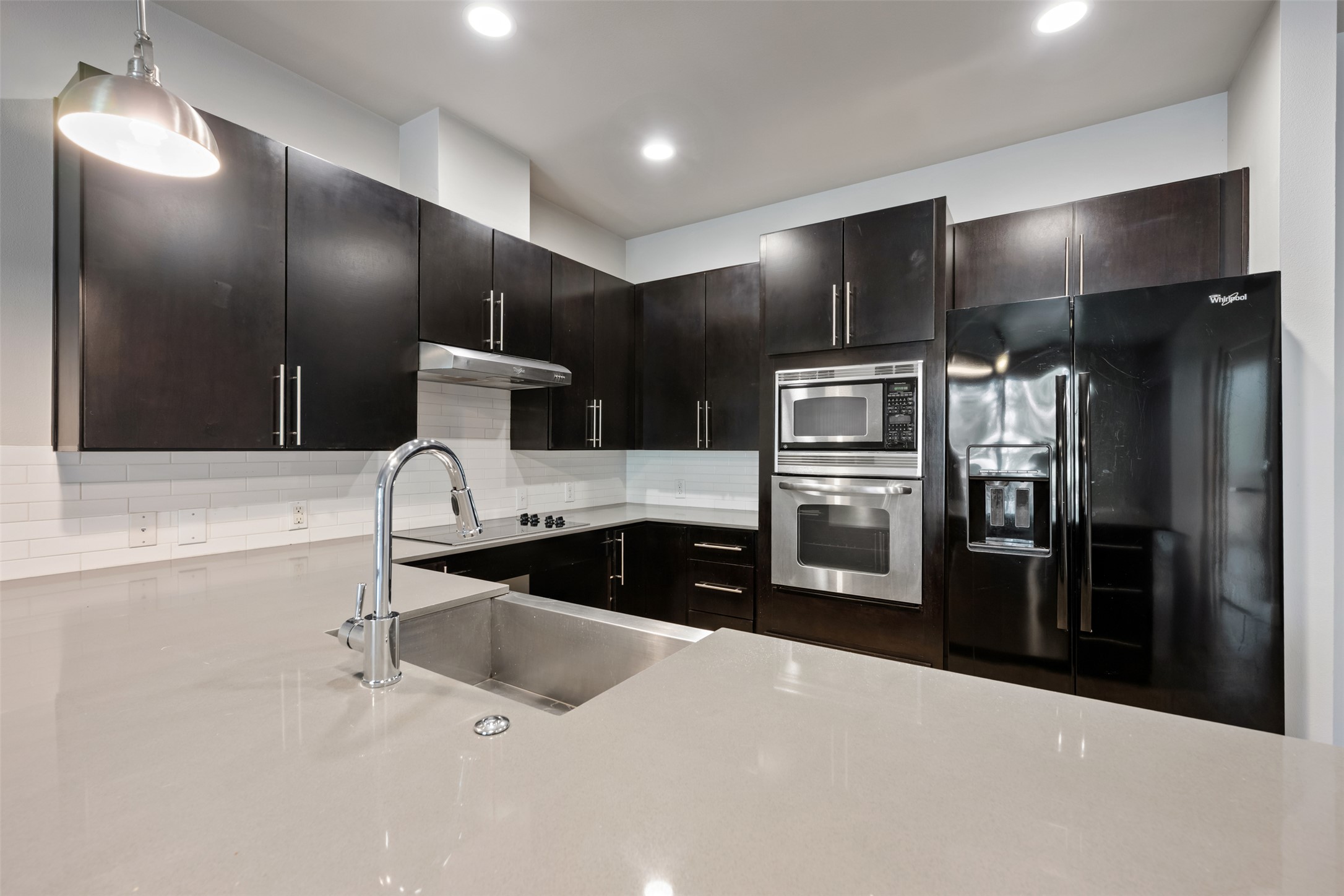 2804 Treble Lane, Unit 902 Austin, TX 78704 - Photo 11 of 31 a kitchen with stainless steel appliances kitchen island granite countertop a refrigerator and a sink