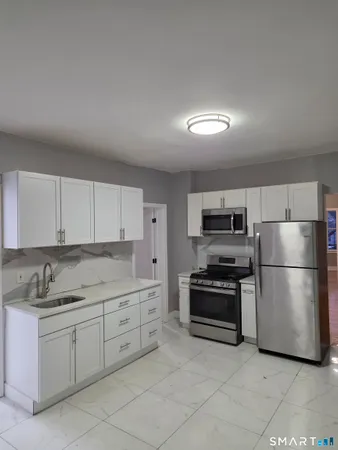 a kitchen with stainless steel appliances granite countertop a refrigerator sink and stove