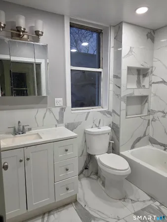 a bathroom with a sink a toilet and shower