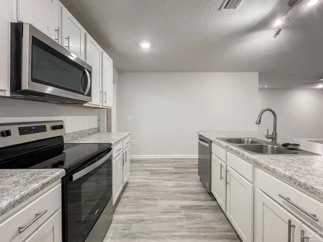 a kitchen with a sink and steel appliances