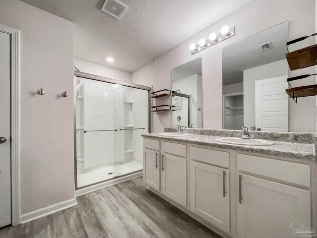 a bathroom with double vanity sink and mirror