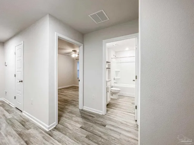 an empty room with a window and a ceiling fan