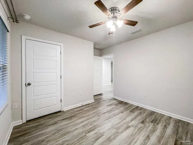 a view of a hallway with wooden floor and closet