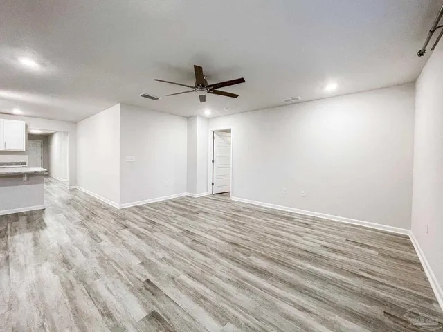 a view of empty room with wooden floor and window