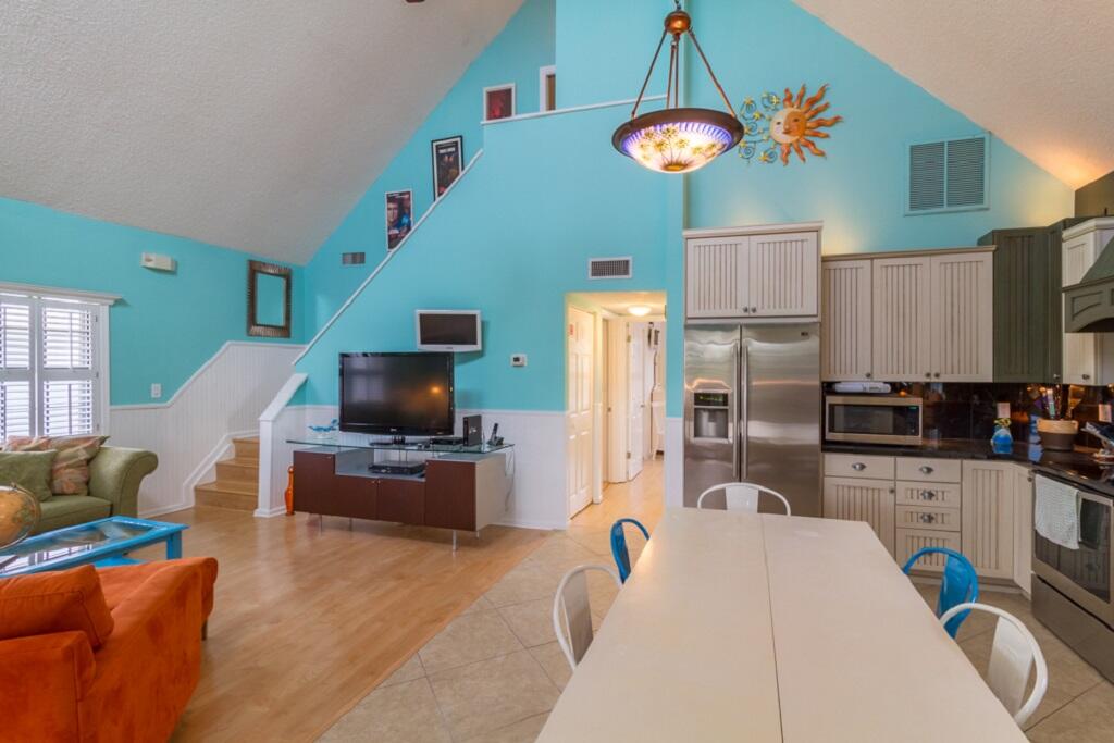 497 Sombrero Beach Road Marathon, FL 33050 - Photo 15 of 33 a kitchen with a refrigerator a stove top oven a sink dishwasher and a dining table with wooden floor