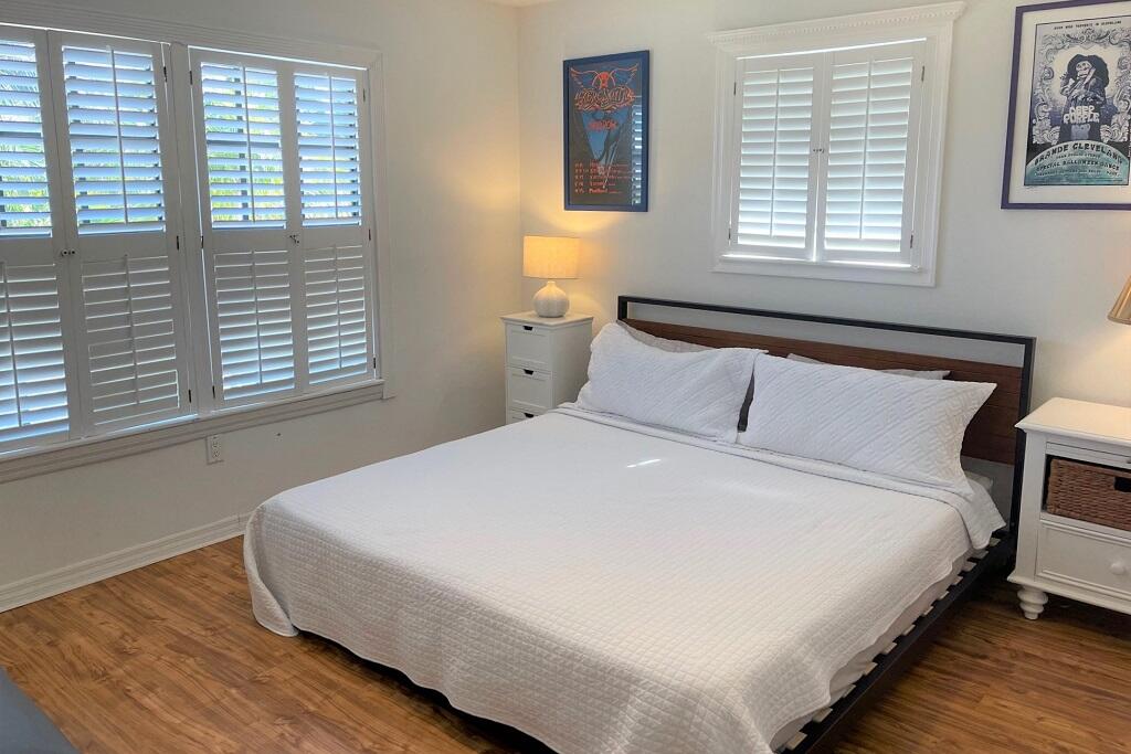 497 Sombrero Beach Road Marathon, FL 33050 - Photo 17 of 33 a bedroom with a bed and wooden floor